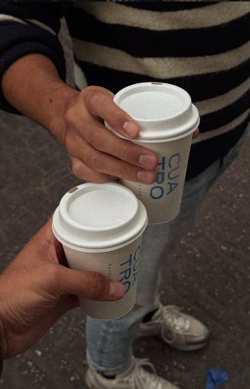 Dos personas brindando con vasos para llevar de La Cuatro