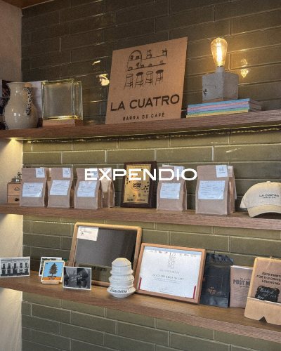 Repisas del expendio de La Cuatro con bolsas de café y reconocimientos