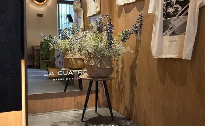 Rincón de La Cuatro con flores secas, espejo y playeras de la marca